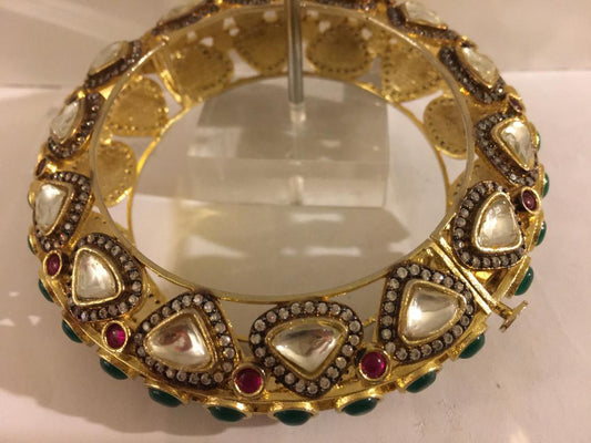 Kundan, emerald stones in gold pltd bangle